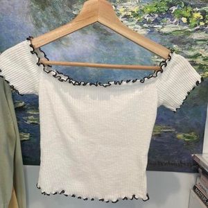 white cropped off shoulder top with black lining